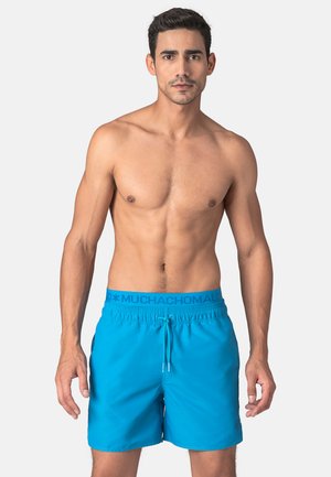Blauwe zwemboxers met een elastische tailleband en trekkoord. Gemaakt van gladde stof, met een logo op de tailleband.