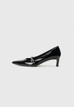 Escarpin noir en cuir verni à bout pointu avec un petit talon, doté d'un détail de bande métallique sur le devant pour une touche d'accent.