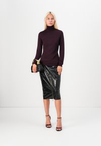 Burgundy turtleneck sweater with patterned texture; black crocodile-embossed pencil skirt with gold zipper detail; black handbag; strappy heels.