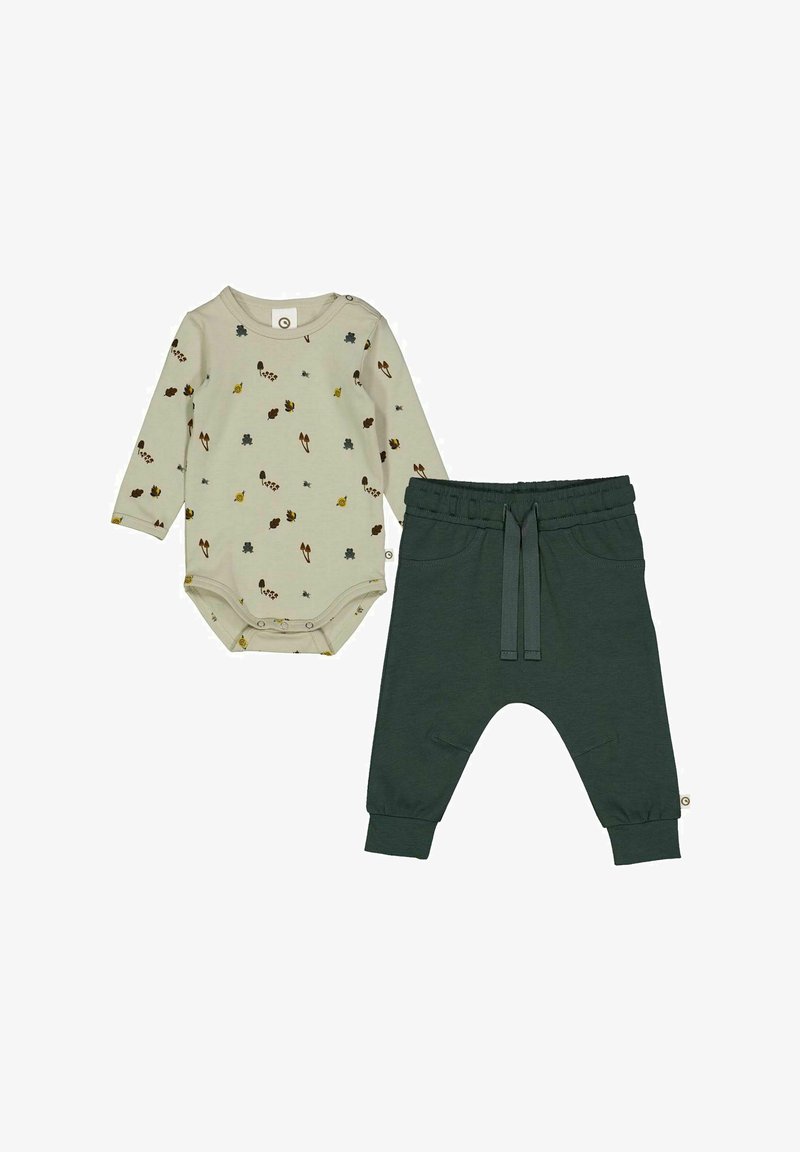 Světle béžový body s dlouhým rukávem a potiskem inspirovaným přírodou, spárovaný s tmavozelenými kalhotami s elastickým pasem, které mají boční kapsy a šnůrku.