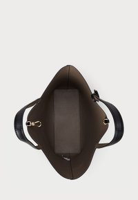 Δερμάτινη τσάντα tote με λείο, σκούρο καφέ εσωτερικό, που διαθέτει υφασμάτινη μαύρη λαβή και χρυσό κλιπ. Ορθογώνια βάση για σταθερότητα.