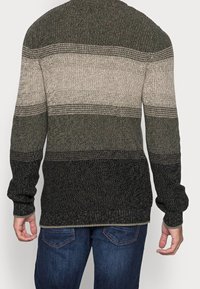 Maglione a maglia con strisce orizzontali in verde scuro, beige e nero. Maniche lunghe e scollatura rotonda con un tessuto testurizzato.