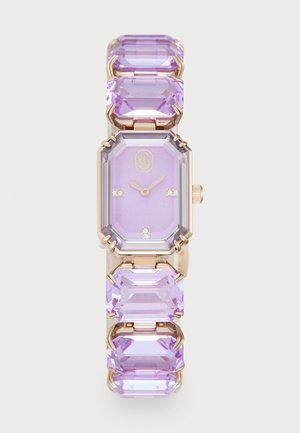 Montre rectangulaire avec un cadran lilas, boîtier en ton doré, et un bracelet orné de trois grandes pierres précieuses violettes. Décorée de petits accents en cristal.