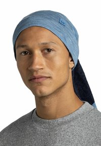 Blue fabric headband with a contrasting darker tail, worn by a person in a grey sweatshirt, featuring a small logo on the side.