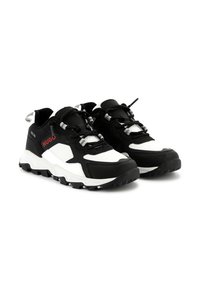 Scarpe da ginnastica in bianco e nero con tomaia in tessuto testurizzato, suola robusta con battistrada e accenti in hardware riflettente.