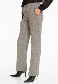 Wollen blend broek, lichtgrijs en zwart houndstooth patroon, rechte pijpen, voorzakken, gecombineerd met puntige zwarte hoge hakken.