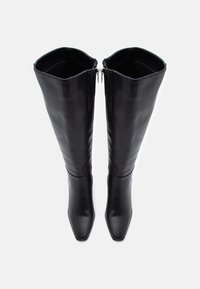 Stivali in pelle nera alti fino alla coscia, con punta quadrata, texture liscia e doppia zip superiore, progettati per una silhouette aderente.