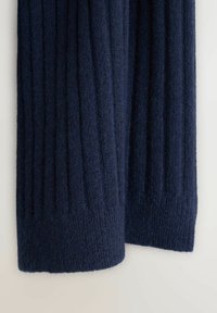 Marineblauw geribd gebreid sweater met een zachte textuur. Heeft verticale strepen en een iets opgerolde zoom aan de onderkant.