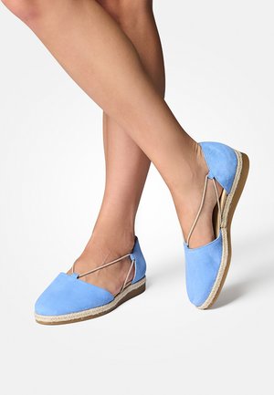 Himmelblaue Wildleder-Espadrilles mit flacher Sohle, ausgestattet mit einem Kreuzriemen-Design und einem natürlichen Jute-Seil-Akzent am Sohlenrand.