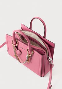 Ροζ δερμάτινη τσάντα χειρός με διπλές λαβές, χρυσά μεταλλικά στοιχεία και αλυσίδες. Διαθέτει φερμουάρ σε ένα χώρο αποθήκευσης και καρδιόσχημη λεπτομέρεια.