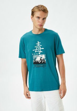 Teal bomulds t-shirt med korte ærmer. Har et centralt grafik i hvid med stiliseret tekst og flammer, crew neck design.