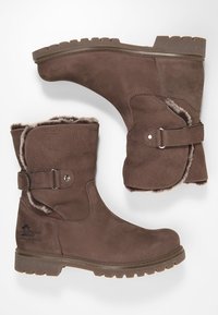 Botines de ante marrón con forro de pelaje sintético, correa ajustable con hebilla y suela de goma resistente con un diseño de banda de rodadura.