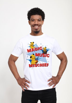 Bílý bavlněný tričko s barevnými grafickými motivy karikatury medvěda a textem "MAGIC MUSIC MISCHIEF" v červené barvě, umístěným na modrém hvězdném vzoru.