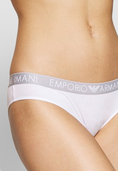 White cotton underwear with a gray elastic waistband featuring "EMPORIO ARMANI" logo. Simple, smooth texture, low-rise design.