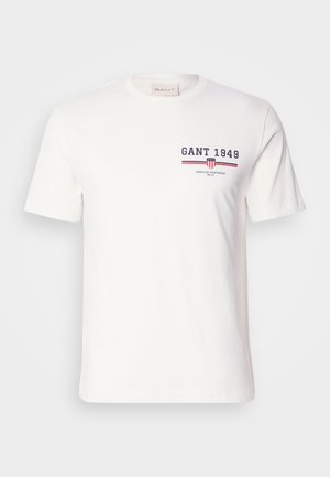 White cotton t-shirt with short sleeves, featuring "GANT 1949" logo in navy and red, and horizontal red and blue striped accents.