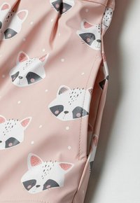 Rozā ūdensizturīga auduma raksts sastāv no raķu sejām un baltām punktiņām. Raķi ir ar melniem un pelēkiem akcentiem, kā arī rozā detaļām.