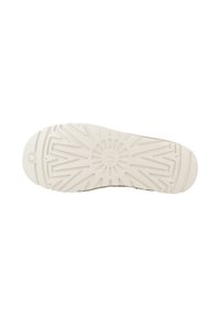Suola della scarpa in gomma beige chiaro con un motivo di presa testurizzato che presenta linee radiali e un emblema circolare vicino al tallone.