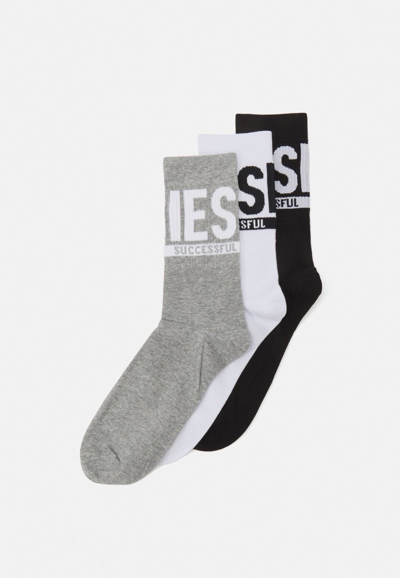 Tres pares de calcetines en gris, blanco y negro. Cada uno tiene una banda con la palabra "EXITOSO". El material parece suave y son de longitud hasta la mitad de la pantorrilla.