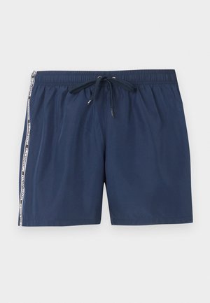 Șort de baie bleumarin cu talie elastică, șnur și dungi albe cu logo-ul Moschino pe părți.