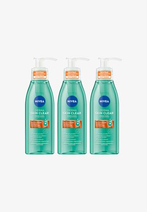 Three transparent green bottles of NIVEA Derma Skin Clear face wash. Bottles feature white pumps, blue logo, and orange labels with product information.