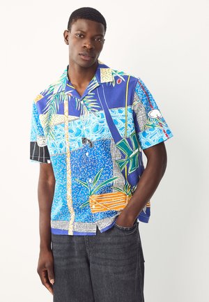 Short-sleeve button-up shirt featuring a vibrant blue and multicolored abstract pattern with palm leaves and geometric details.