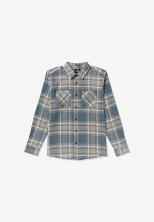 Rutig flannel skjorte i nuancer af blå og creme, med spredt krave, lange ærmer, og to brystlommer med sorte knapper.