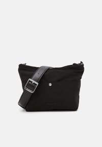 Sort nylon crossbody taske med lynlås, justerbar læderrem, metalliske detaljer og et logo på forsiden. Glat tekstur.