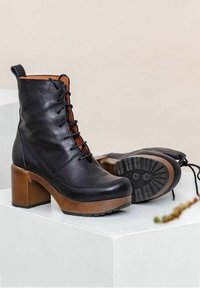 Black leather lace-up ankle boots with a brown block heel, featuring a textured rubber sole and a smooth finish on the upper.