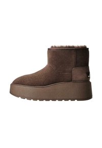 Stivale alla caviglia in suede marrone con colletto morbido e testurizzato. Presenta una suola piattaforma spessa e scanalata e cuciture rinforzate lungo le cuciture.