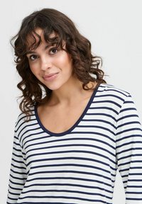Gestreepte langesleeve-top met marineblauwe en witte horizontale strepen, een ronde halslijn en een zachte, gladde textuur.