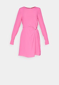Robe longue rose vif à manches longues avec un col rond et un détail de nœud froncé à la taille, arrivant à mi-cuisse sur un fond uni.