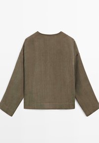 Chemise marron à manches longues avec un col rond et une coupe ample, présentée à plat de dos sur un fond blanc.