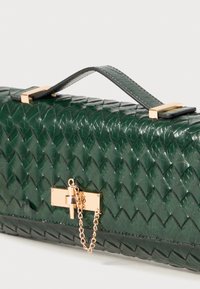 Grüne geflochtene Lederhandtasche mit rechteckiger Form, goldenen Beschlägen, Kettendetail und einem oberen Griff zum Tragen. Strukturierten Oberfläche.