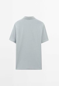 Lys grå polo-shirt, korte ærmer, blødt bomuldsstof, klassisk krave, ensfarvet design, ingen synlige mønstre eller accenter.