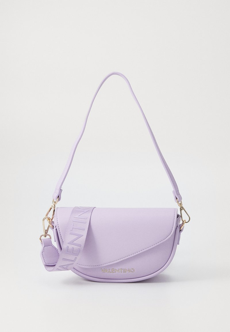 Ljubičasta sintetička crossbody torba s zakrivljenim oblikom, opremljena remenom s logotipom i zlatnim detaljima. Glatka tekstura, minimalistički dizajn.