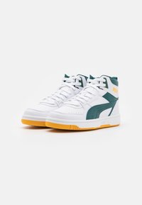 Białe sneakersy typu high-top z syntetycznego materiału z zielonymi akcentami i żółtą gumową podeszwą. Posiadają wyszywane logo i perforowane detale.