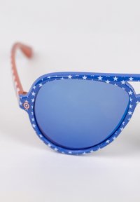Blue sunglasses with star-patterned frame, blue lenses, and red accents on the temples. Frame has a rounded shape and glossy finish.