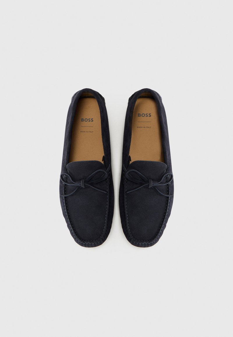 Navy blue suede loafers with bow detail, tan insoles labeled "BOSS Made in Italy," displayed side by side on a white background.