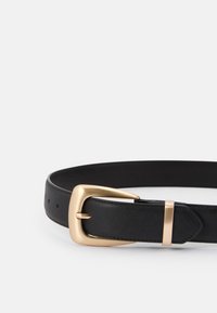 Curea din piele neagră cu un cataramă rectangulară aurie și accente metalice. Dispune de mai multe găuri de ajustare pe curea pentru mărire.