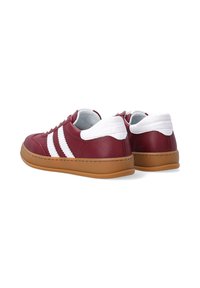 Bordeauxrote Ledersneaker mit weißen Akzenten und drei Streifen. Ausgestattet mit einer weißen Ferse und einem gepolsterten Kragen, auf einer Gummisohle.