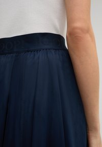 Jupe midi marine avec une large taille élastique arborant le logo en relief "JOOP!", fabriquée dans un tissu léger au toucher doux.