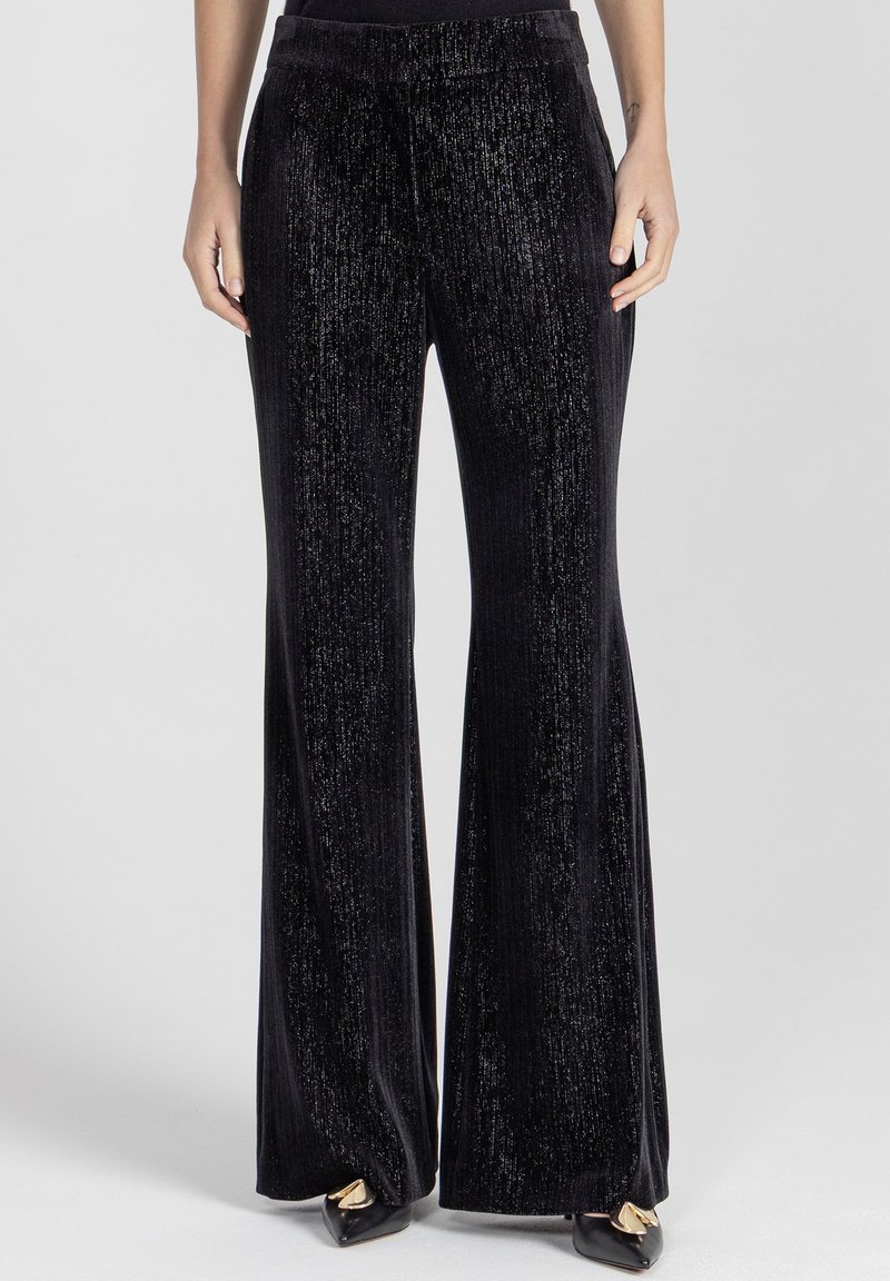 Czarne aksamitne dzwony z teksturowanym, błyszczącym wykończeniem. Posiadają wysoki stan i gładki pas, odpowiednie do noszenia na formalne lub codzienne okazje.