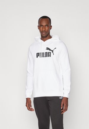 Witte hoodie met een voorzak en een koord, met een zwart 'PUMA' logo en kattensilhouet. Gecombineerd met donkergrijze trainingsbroek.