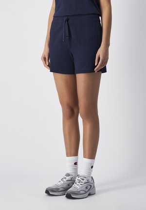 Navy blue shorts made of soft material with an elastic waistband and adjustable drawstring. Paired with gray sneakers and white socks.