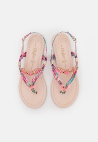 Sandalias planas con tiras estampadas en rosa, azul y verde, acentos dorados y adornos florales. Plantilla beige con detalle del logo.