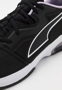 Czarny but sportowy z fakturowaną tkaniną na wierzchu, białymi akcentami oraz solidną gumową podeszwą z przezroczystym detalem poduszki powietrznej.