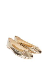 Ballet flats metallici dorati con punta arrotondata, suola piatta e un piccolo fiocco decorativo sul davanti. Texture liscia e design slip-on.