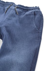 Blue denim jogger pants with elastic waistband, black and white drawstrings, and side pockets, shown on white background.