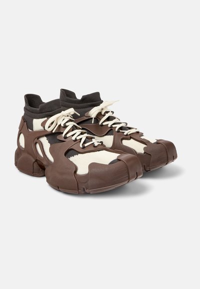 Sneaker marroni e crema con un design unico, caratterizzati da una tomaia testurizzata, collo a maglia e lacci a contrasto. Suola in gomma resistente.