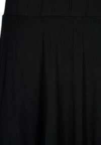 Černá sukně s plisovaným pasem a hladkým, texturovaným materiálem. Design je plynulý a bezešvý, zdůrazňující jednoduchou estetiku.